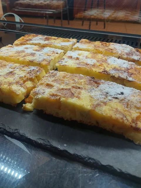 Apfelkuchen in Stücken mit Puderzucker in der Vitrine
