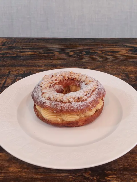 Paris-Brest mit Puderzucker auf einem weißen Teller